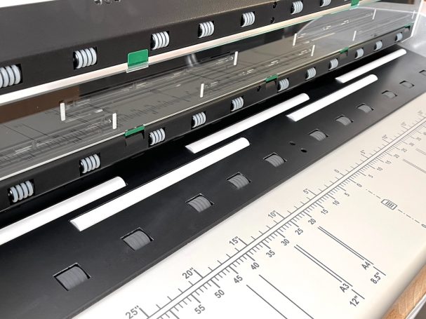 Schwarze und silberne Lineal mit Markierungen auf einem flachen Untergrund.